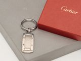 a silver keychain sitting on top of a red box