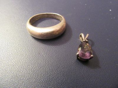 une bague en argent et une bague sertie d'une pierre rose posées sur une table