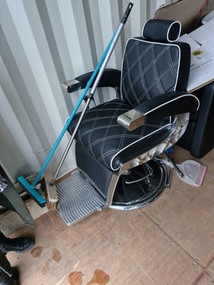 a black and white barber chair with a blue handle