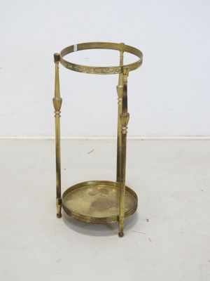 une table d'appoint plaquée laiton, à deux pieds et dotée d'un plateau en verre