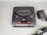 a small game console with a charger and a power cord