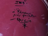 a red plate with writing on it sitting on a table