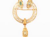 an image of a gold broochle with emeralds and pearls