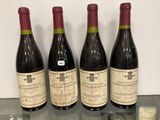 trois bouteilles de vin posées sur une table en verre, à côté d'une bouteille de vin