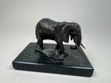 a statue of an elephant that is standing on a marble base