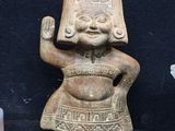 some old pottery figurines are sitting on a black surface