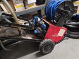 un chariot avec un tuyau et un tuyau posé par terre