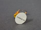 a small white button with a yellow and red ribbon on it