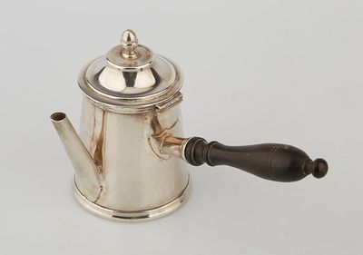 an antique silver coffee pot with a wooden handle on a white surface