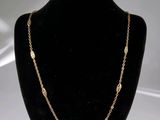 un collier à chaîne en or présenté sur un mannequin, sur fond blanc