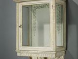 une petite armoire blanche avec un miroir accroché au mur