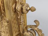 an image of a gold colored clock with ornate carvings on it