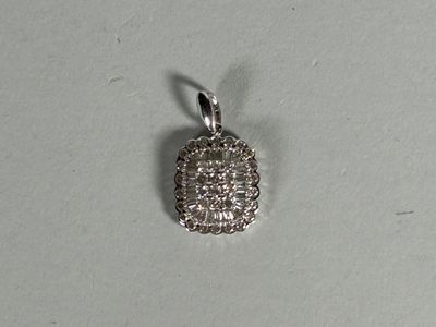 a close up of a small silver pendant on a white surface
