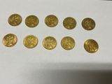a bunch of gold coins sitting on top of a white table