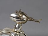 a silver plate with a bird on top of it