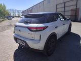 the rear end of a white suv parked in front of a building