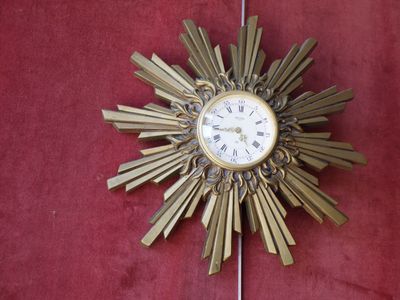 a clock that is on the wall with a starburst