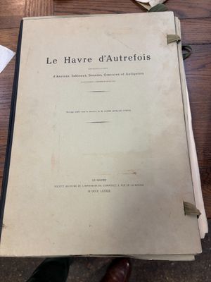 un vieux livre posé sur une table en bois à côté d'une tasse de café
