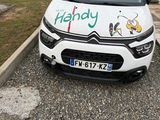 une petite voiture blanche avec un autocollant à l'avant