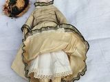 a doll that is laying on the ground next to a bowl