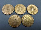 four gold sovereigns, one of which has a cross on it