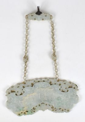 un gros plan d'un collier suspendu à une chaîne sur une surface blanche