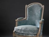 une chaise bleue dans une pièce sombre, sur fond noir