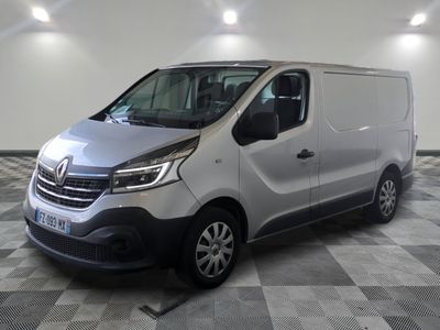 La camionnette argentée est garée sur un sol à damier dans un garage.