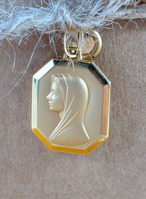 a gold medal with a picture of a woman on it