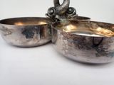 a silver bowl and a silver bowl on a white table