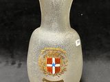un vase en verre orné d'un blason
