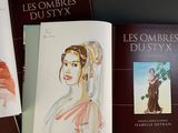 three books on a table with a drawing of a woman in a dress