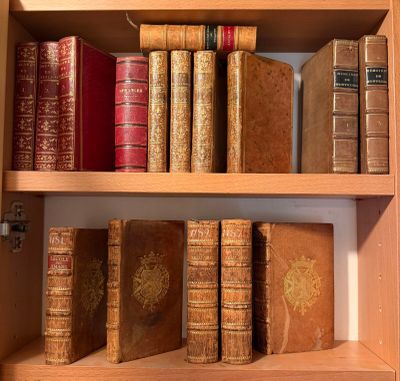 de nombreux livres anciens posés sur une étagère en bois dans une pièce