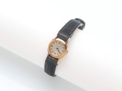 une montre posée sur une surface blanche