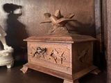 une petite boîte en bois posée sur une étagère dans un coin de la pièce
