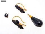 pair of black and gold earrings with a black faceted stone