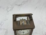 a small clock that is sitting on a marble table