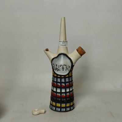 un vase contenant une brosse à dents, à côté d'un porte-brosse à dents
