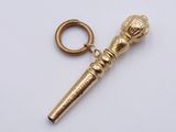a gold keychain that has a microphone on it