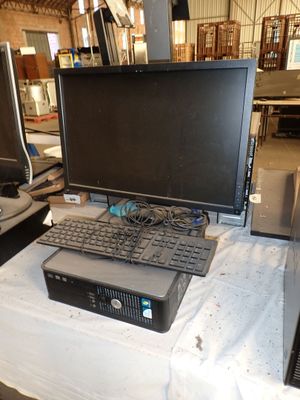 un ordinateur posé sur une table, avec un clavier et un écran