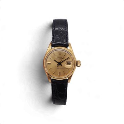 une image d'une montre-bracelet en or avec un bracelet en cuir noir