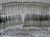 many forks and spoons laid out on the table