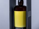 une bouteille vide dans une boîte noire avec une étiquette jaune