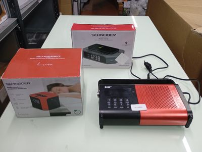 a red and black radio sitting on a table next to a box