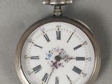 une montre de poche en argent avec des chiffres romains