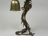 an image of a bronze statue of a dragon holding a bell