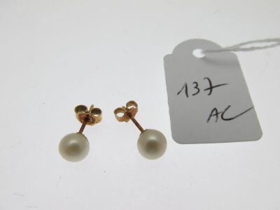 une paire de boucles d'oreilles en perles et en or avec une étiquette de prix