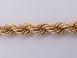 a close up of a gold chain on a white surface
