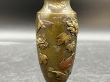 un vase en or orné de fleurs, posé sur une table