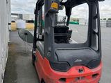a red forklift truck parked in a parking lot